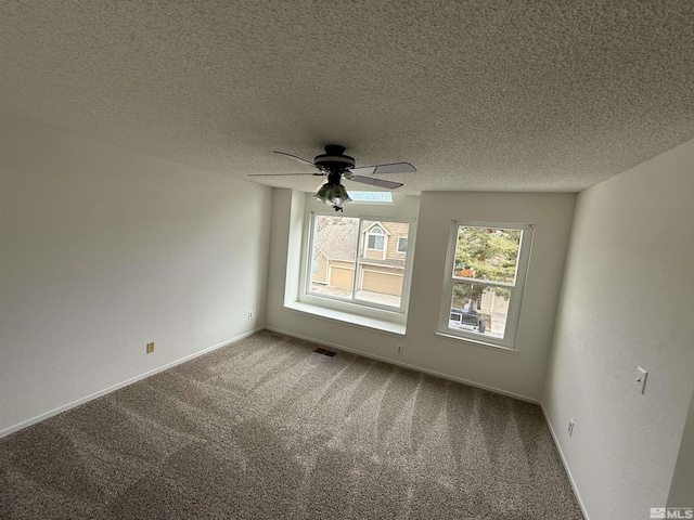 empty room featuring ceiling fan, carpet flooring, and a textured ceiling