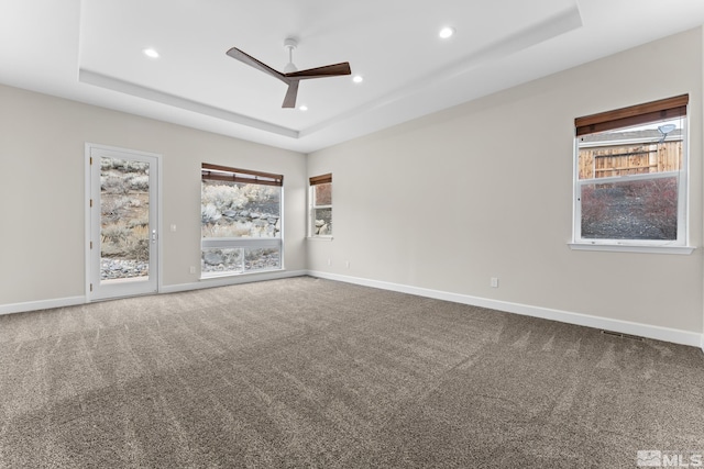 spare room featuring ceiling fan, carpet flooring, and a raised ceiling