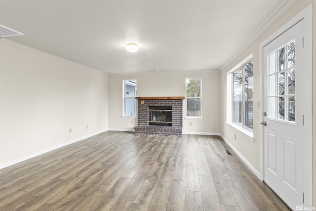 unfurnished living room with hardwood / wood-style flooring, crown molding, and a fireplace