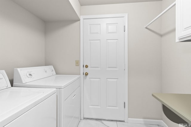 clothes washing area with washer and clothes dryer and cabinets