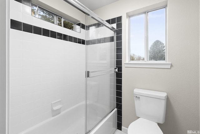 bathroom featuring enclosed tub / shower combo and toilet