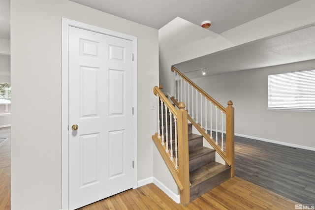 stairs featuring hardwood / wood-style floors