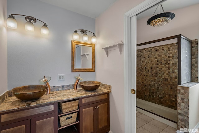 bathroom featuring vanity, a tile shower, and tile patterned floors