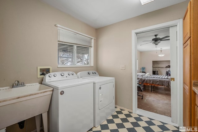 laundry area with sink, washing machine and clothes dryer, and ceiling fan