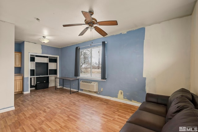 living room featuring a wall mounted AC, ceiling fan, and light hardwood / wood-style flooring