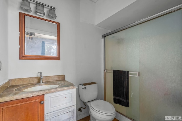 bathroom with vanity, toilet, and an enclosed shower