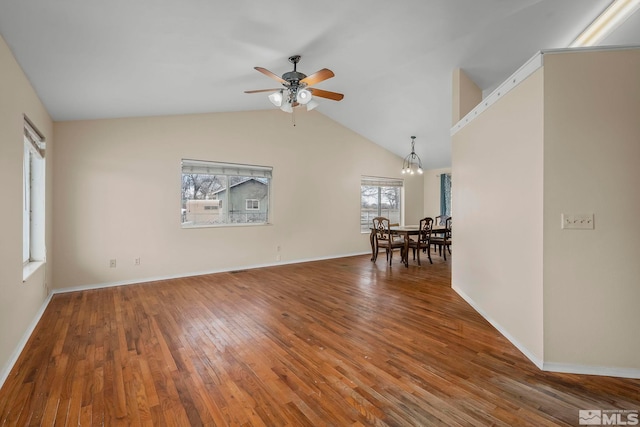 spare room featuring ceiling fan with notable chandelier, lofted ceiling, and hardwood / wood-style floors