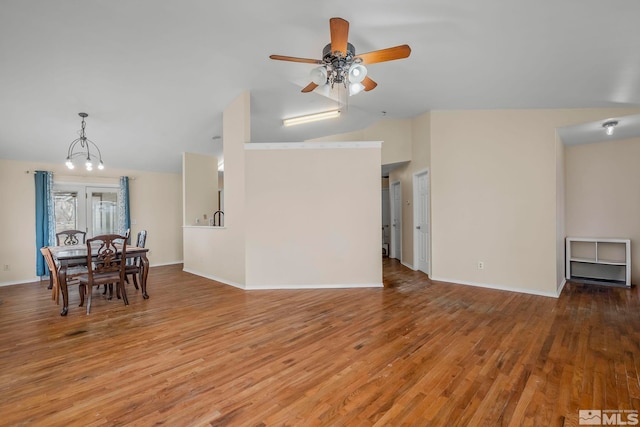 interior space featuring lofted ceiling, ceiling fan with notable chandelier, and light wood-type flooring