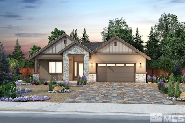 view of front of property with a garage, stone siding, fence, and board and batten siding