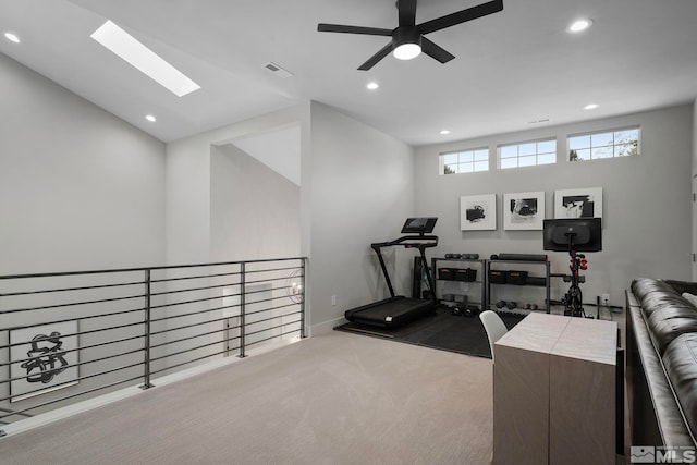 exercise room with lofted ceiling with skylight and light carpet