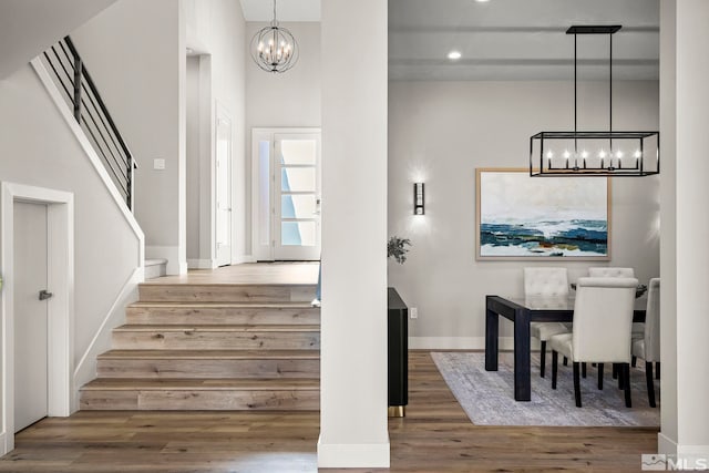 stairway with hardwood / wood-style flooring and a chandelier