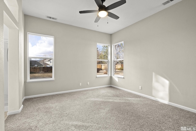 carpeted spare room featuring ceiling fan