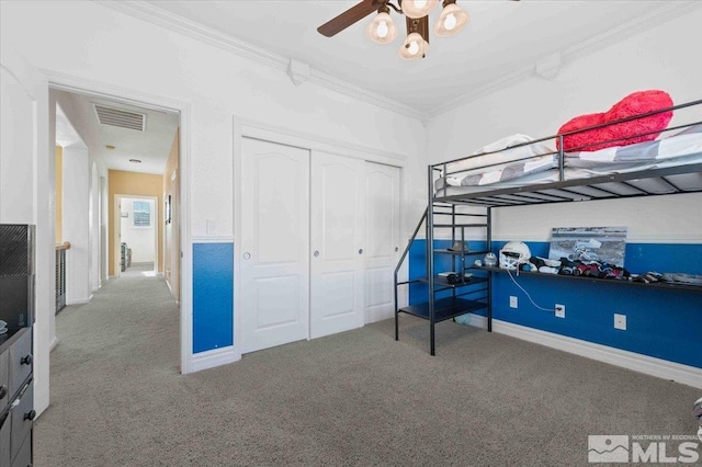 bedroom with crown molding, carpet floors, and a closet