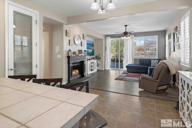 interior space featuring tile patterned flooring and ceiling fan with notable chandelier