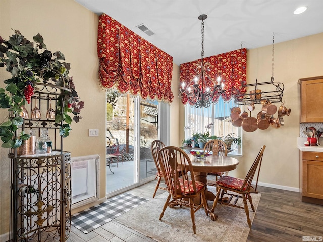 dining area featuring hardwood / wood-style flooring and a notable chandelier