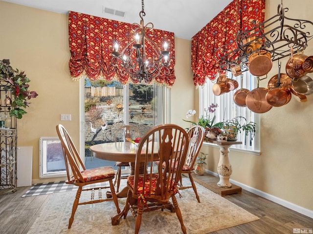 dining room featuring dark hardwood / wood-style floors and an inviting chandelier