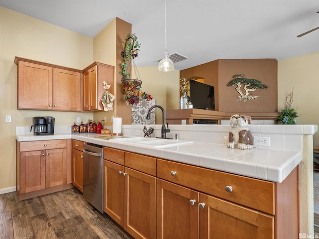 kitchen featuring dishwasher, dark hardwood / wood-style flooring, decorative light fixtures, tile countertops, and kitchen peninsula