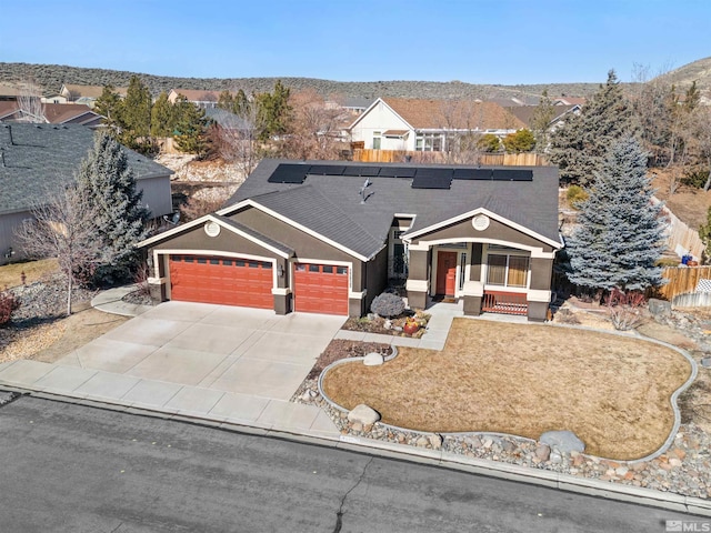 single story home with a mountain view, a garage, solar panels, and covered porch