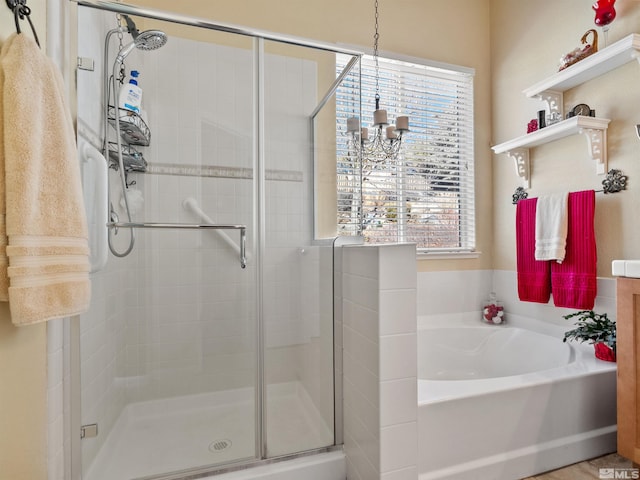 bathroom with shower with separate bathtub and a chandelier