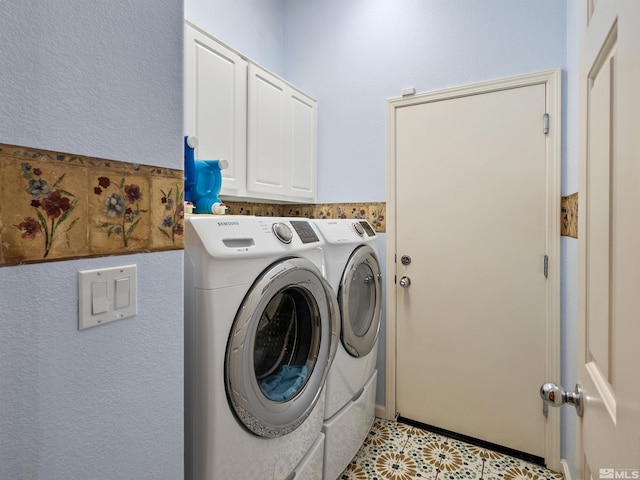 washroom with washer and clothes dryer and cabinets