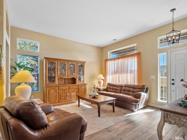 living room featuring light hardwood / wood-style floors and a notable chandelier