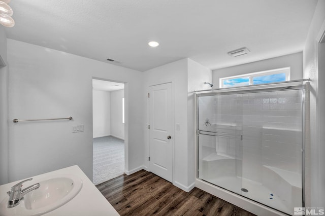 bathroom featuring vanity, hardwood / wood-style floors, and walk in shower