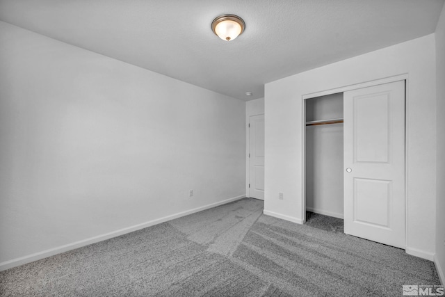 unfurnished bedroom with a closet, a textured ceiling, and carpet flooring