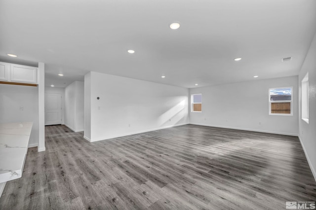 unfurnished living room featuring a healthy amount of sunlight and light wood-type flooring