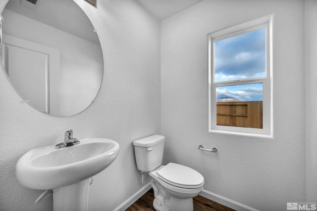 bathroom featuring hardwood / wood-style flooring and toilet