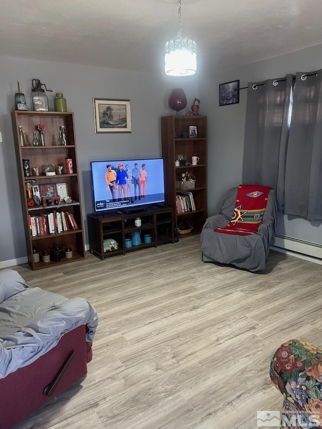 living room with a baseboard heating unit and light wood-type flooring