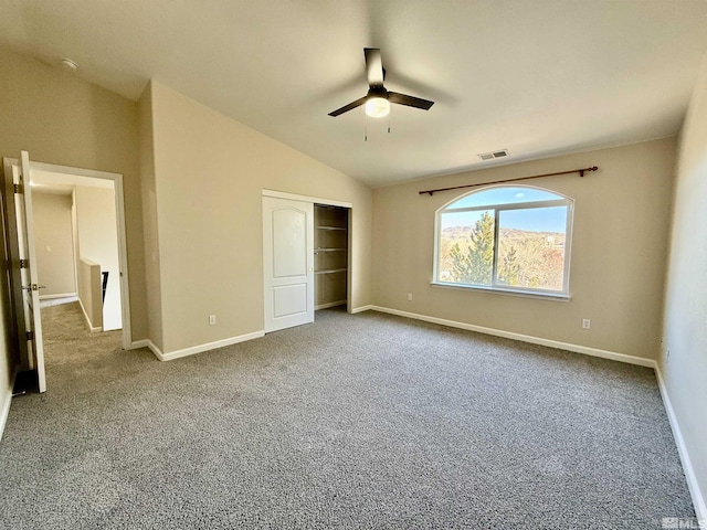 unfurnished bedroom featuring ceiling fan, carpet floors, vaulted ceiling, and a closet