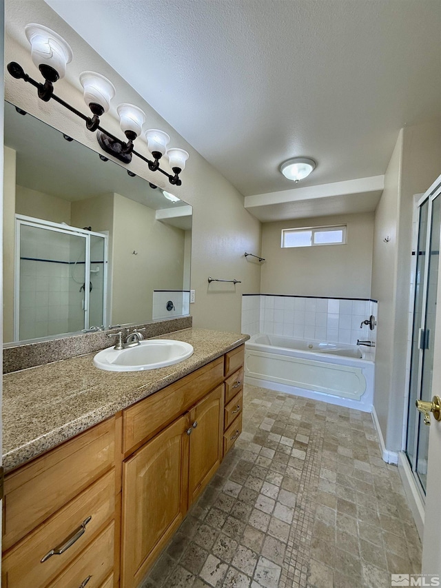 bathroom featuring vanity, plus walk in shower, and a textured ceiling