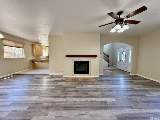 unfurnished living room with a fireplace, light hardwood / wood-style floors, and ceiling fan