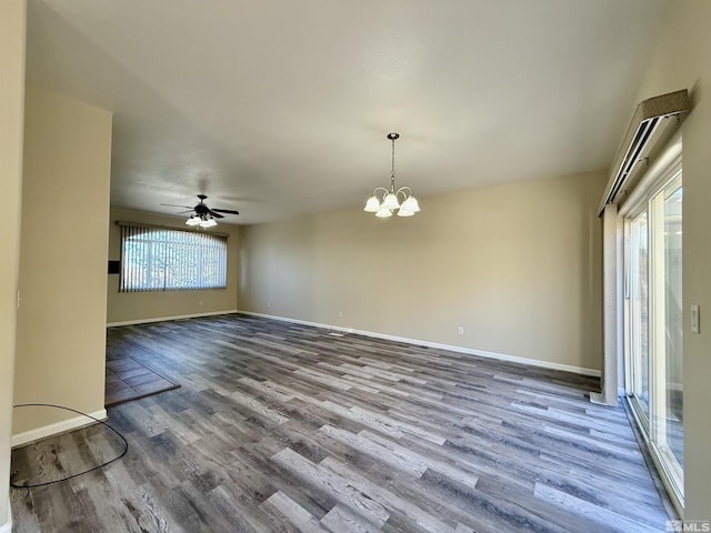 empty room with ceiling fan with notable chandelier and hardwood / wood-style floors