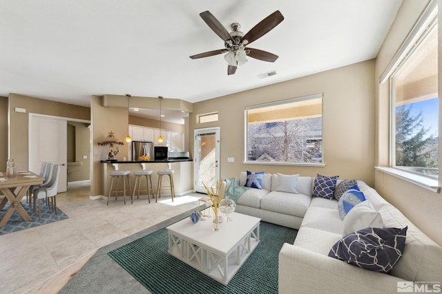 living room featuring light tile patterned flooring and ceiling fan