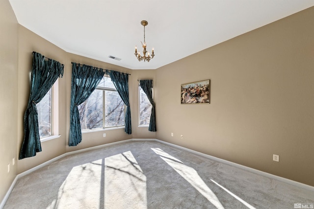 unfurnished room with carpet flooring and a chandelier