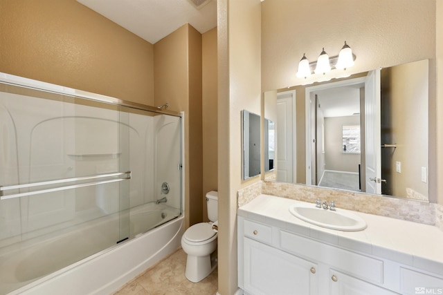 full bathroom featuring vanity, tile patterned flooring, shower / bath combination with glass door, and toilet