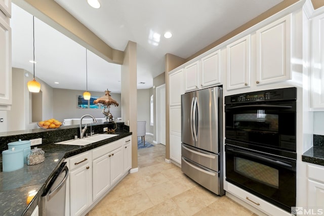 kitchen featuring sink, appliances with stainless steel finishes, pendant lighting, dark stone counters, and white cabinets