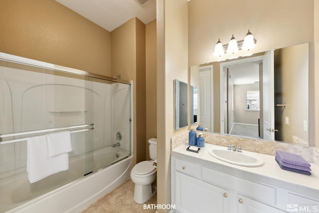 full bathroom featuring vanity, shower / bath combination with glass door, and toilet