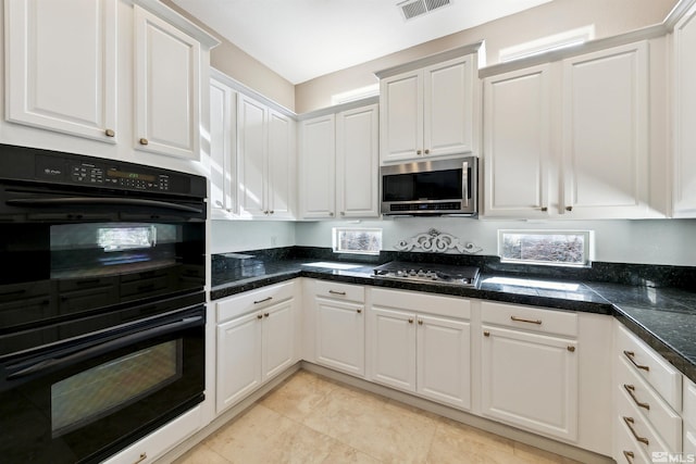 kitchen with stainless steel appliances, light tile patterned floors, and white cabinets