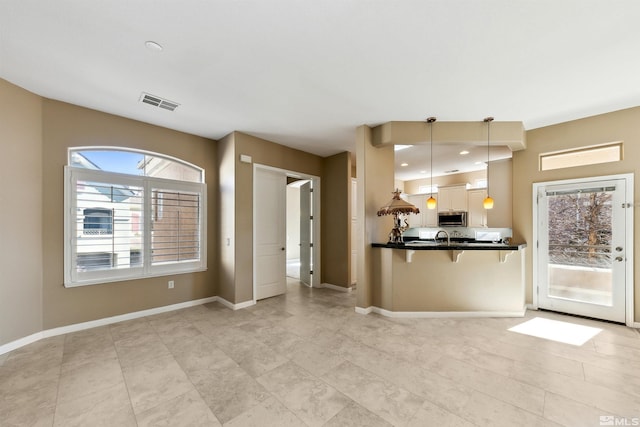 kitchen featuring sink, a breakfast bar area, and pendant lighting