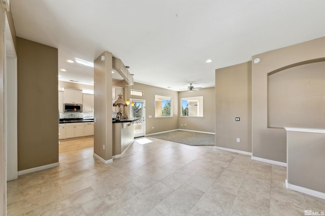 kitchen with pendant lighting, ceiling fan, and white cabinets