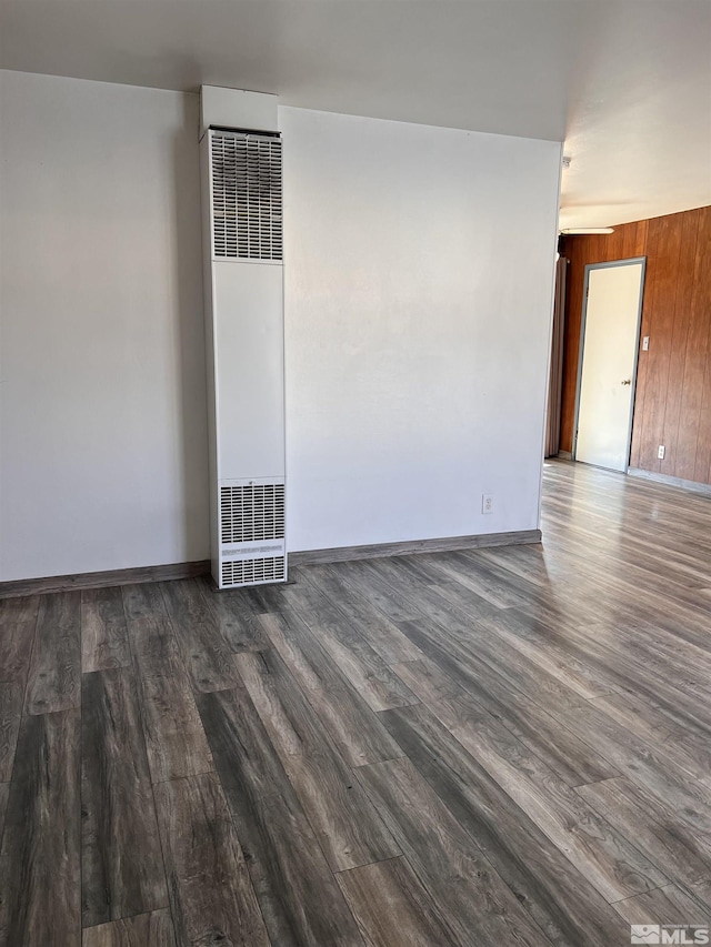 unfurnished room featuring dark hardwood / wood-style flooring and wood walls