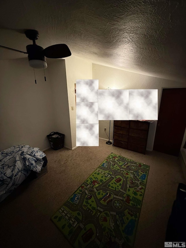 carpeted bedroom with lofted ceiling, a ceiling fan, and a textured ceiling