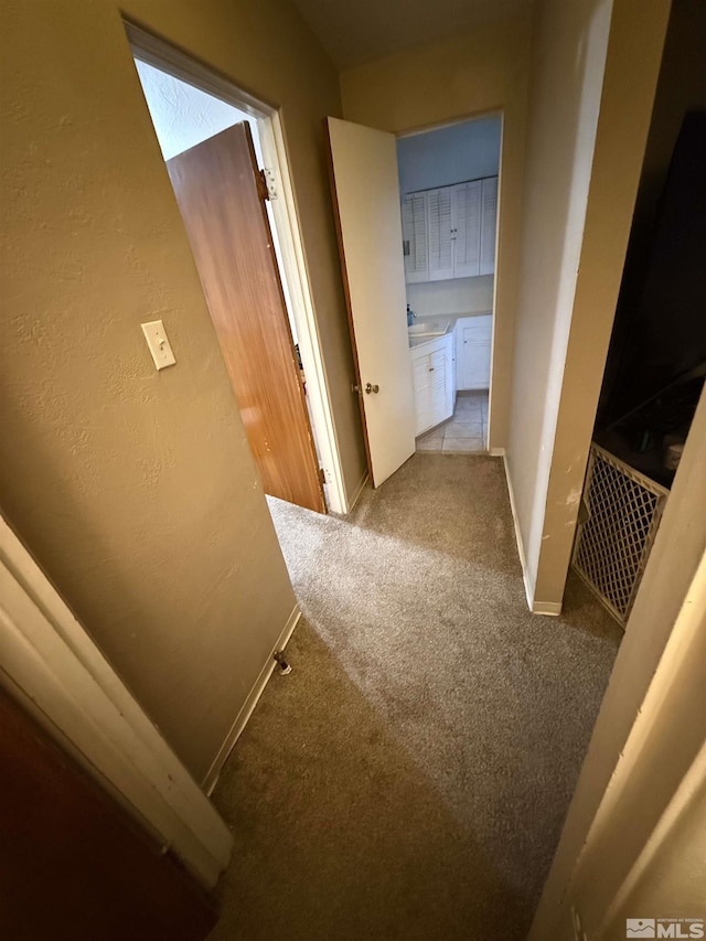 corridor with carpet flooring and baseboards