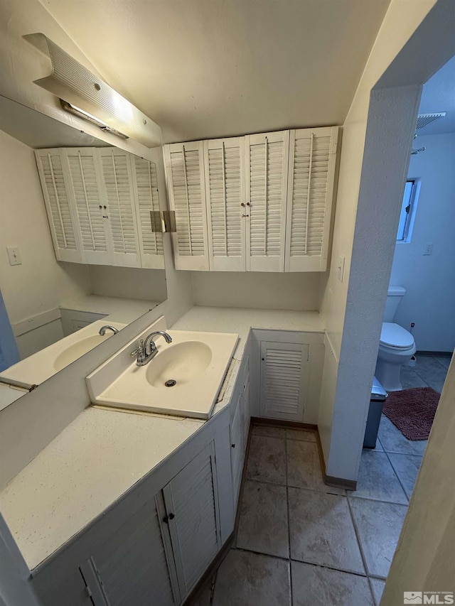 bathroom with vanity, toilet, and tile patterned flooring