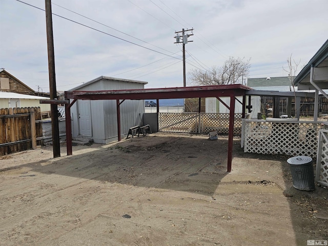 view of patio / terrace with a storage unit, an outbuilding, and fence
