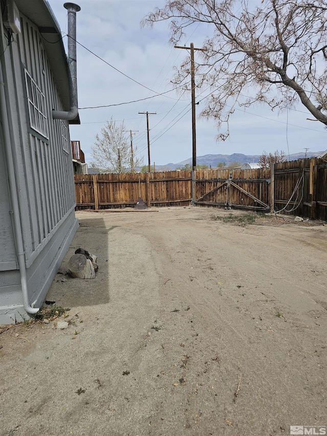 view of yard with a fenced backyard and a mountain view