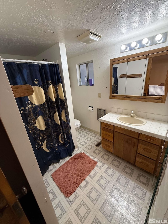 full bathroom with tile patterned floors, a textured ceiling, toilet, a shower with shower curtain, and vanity