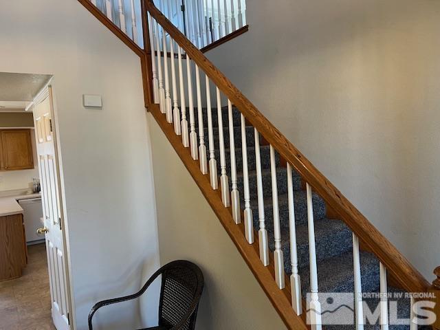 stairway featuring a towering ceiling